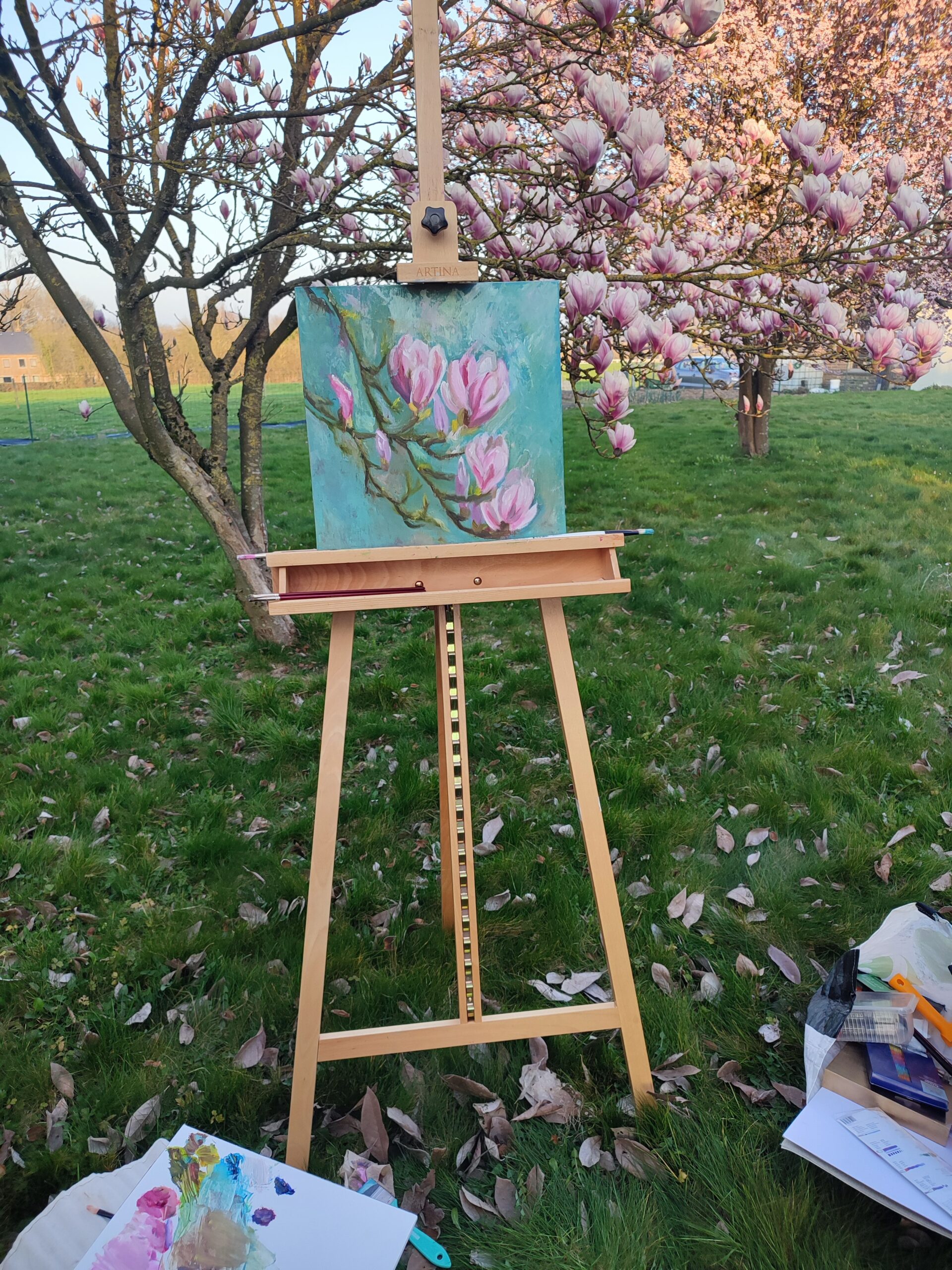 The garden nearby Namur, showing a flowering tree and painting easel set up for a relaxing art retreat