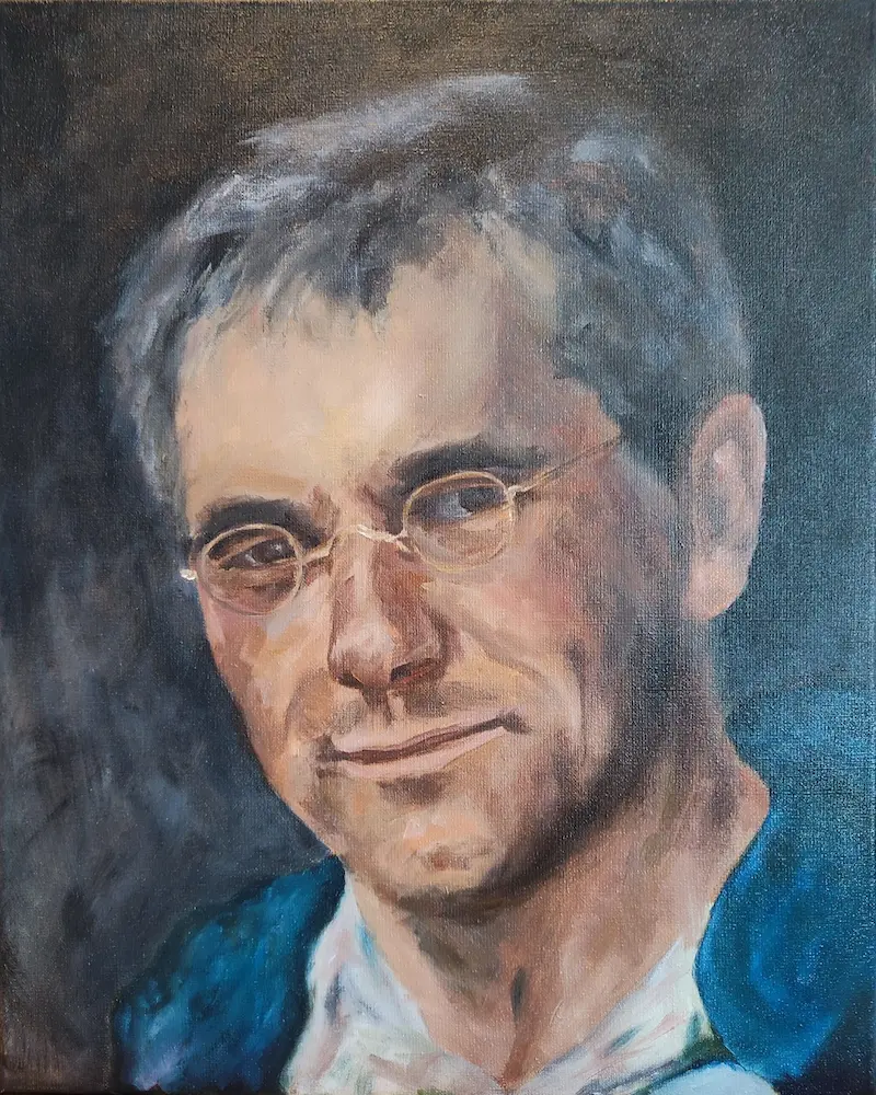 A man with glasses in a blue jacket